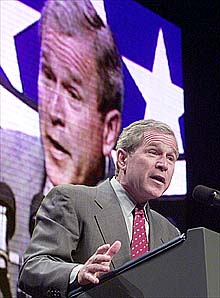 [ George W Bush speaking in front of picture of George W Bush speaking ]