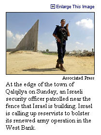 [ Soldier guarding wall to keep suicide bombers out of Israel (under construction) ]